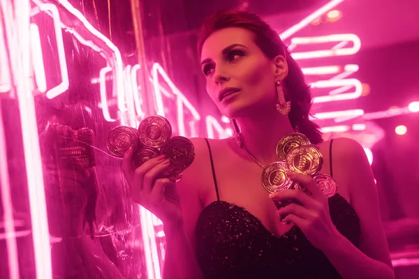 A glamorous woman holding casino chips in a neon-lit environment, representing the premium online casino atmosphere of BDKK.