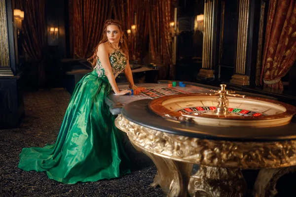 A woman in a luxurious green gown next to an ornate roulette wheel, capturing the upscale casino mood of BDKK.